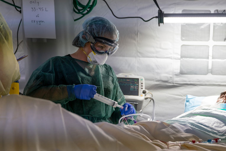 Enfermeira verifica tubo de alimentação de paciente Enfermeira verifica tubo de alimentação de paciente